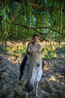 Young girl sitting on her horse under a tree, Othenstorf, Mecklenburg-Western Pomerania, Germany