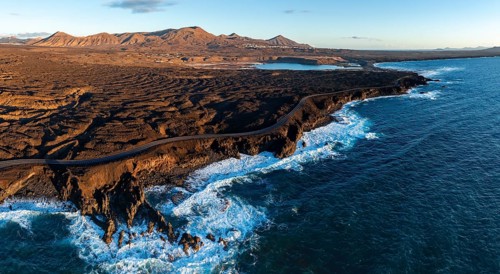 Coast with lava fields, volcanic landscape near Los Hervideros, in the evening light, aerial view,