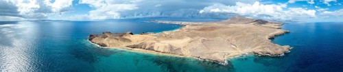 Headland and blue sea, coastal landscape, arid landscape of Los Ajaches Natural Park, aerial view,