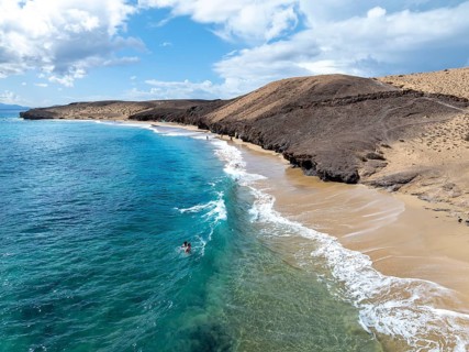 Coast with Playa Caleta del Congrio beach and blue sea, arid landscape of Los Ajaches Natural Park,