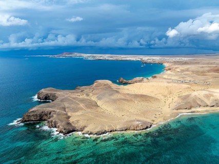 Coast with Playa de Papagayo beach and Playa Caleta del Congrio and blue sea, dry landscape of Los