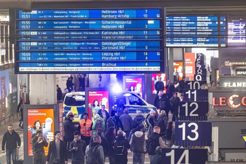 Travelers at the main train station, passengers and departure board at Stuttgart main station.