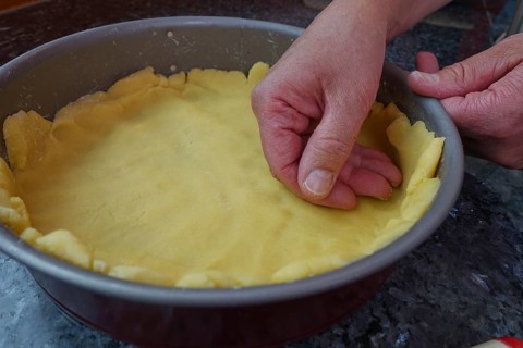 Southern German cuisine, preparation shortcrust pastry, put raw dough in the baking pan, press