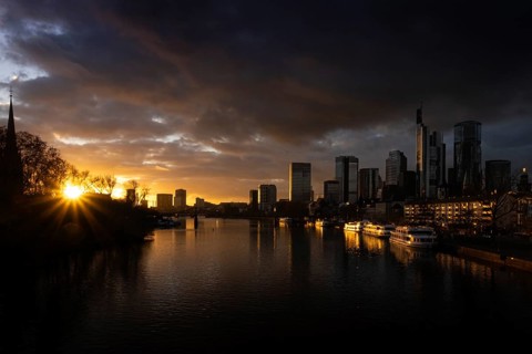 The sun sets behind the Main and bathes Frankfurt's banking skyline in orange-yellow light, Alte