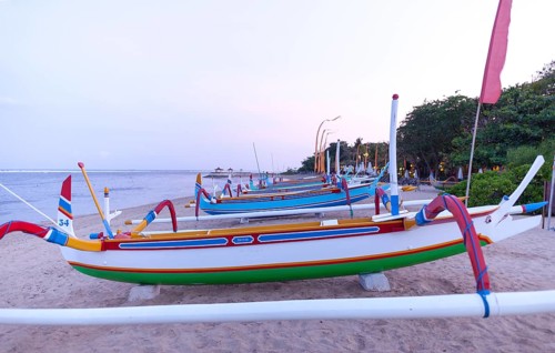 Colourfully painted outrigger fishing boats, (Junkung), on Sanur beach, Bali, Indonesia
