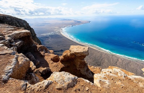View from the Risco de Famara Cliff to Famara Beach, Playa de Famara with La Calaeta, Lanzarote,