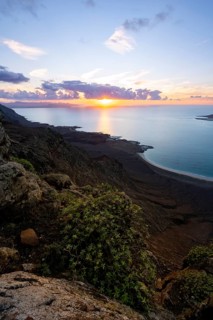 View from steep cliffs to sea and coast with sun stars, Mirador del Porrito viewpoint at sunset,