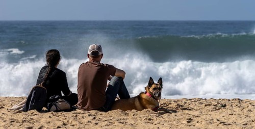 Tourists watch the waves of the Atlantic on the rocky plateau of Sito, also known as Forte São