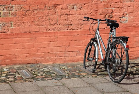 Bicycle parked in front of a red brick wall