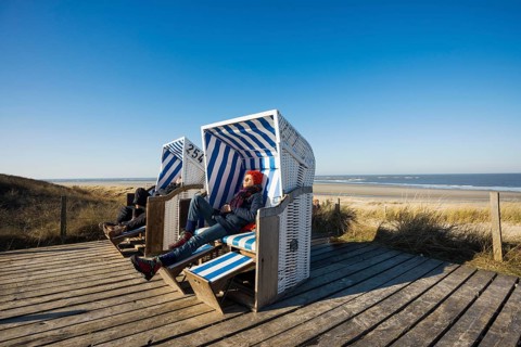 Beach chairs in the dunes and blue sky in winter, Spiekeroog, East Frisian Islands, Lower Saxony,