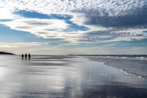 Walkers on the Wadden Sea near the East Frisian island of Spiekeroog, west of the North Sea island,