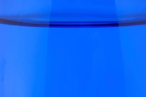 Glass with mineral water, small carbonated pearls on the edge of the glass, drinking water