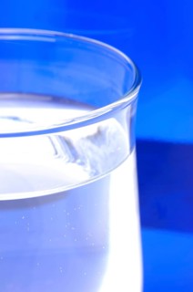 Glass with mineral water, small carbonated pearls on the edge of the glass, drinking water