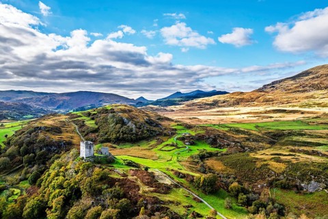 Autumn colours over Castell Dolwyddelan and Eryri Mountains from a drone, Snowdonia, Conwy County