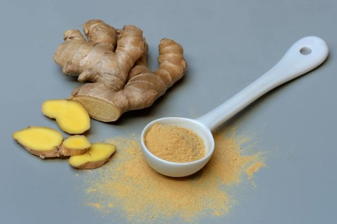 Ginger root and ginger powder in spoon, Zingiber officinale