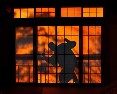Shadow of a man, burglar with knife, assassin, ninja, on the balcony behind sliding shoji doors in