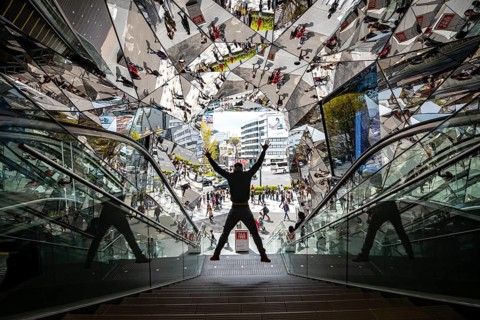 Young man on a stairway, entrance to a shopping center with many mirrors, Tokyu Plaza Omotesando