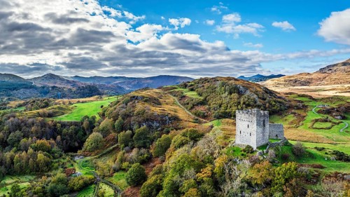 Autumn colours over Castell Dolwyddelan and Eryri Mountains from a drone, Snowdonia, Conwy County