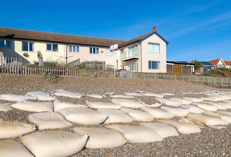 For Sale estate agent signs outside houses at risk of coastal erosion, Thorpeness, Suffolk, North