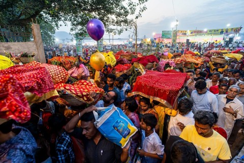 Hindu devotees gather on the banks of the Brahmaputra River to offer prayers to the Sun God on the