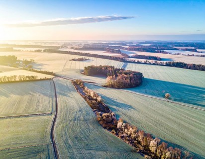 Bird Eye Perspective of Frost Covered Farmland. Seasonal Agricultural Scenery, winter and autumn