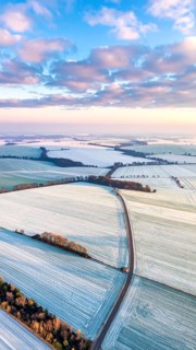 Bird Eye Perspective of Frost Covered Farmland. Seasonal Agricultural Scenery, winter and autumn