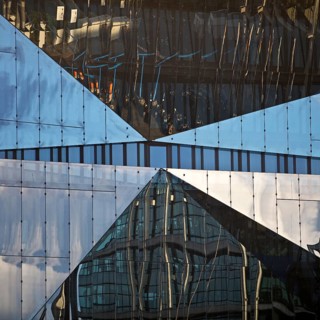 Cube Berlin, cube-shaped office building with folded glass façade reflecting the surroundings,