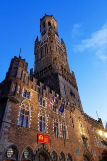 Illuminated Belfry in the historic city centre of Bruges in the evening light, Belfort and City