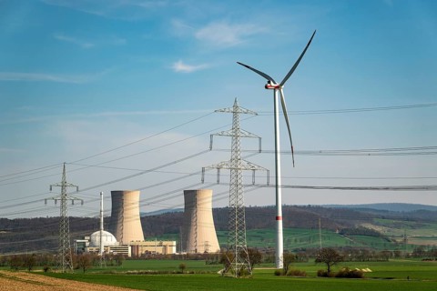 Distant view of the Grohnde nuclear power plant, with wind turbine, electricity pylons and power