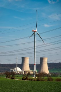 Distant view of the Grohnde nuclear power plant, dominated by a wind turbine, power lines in the