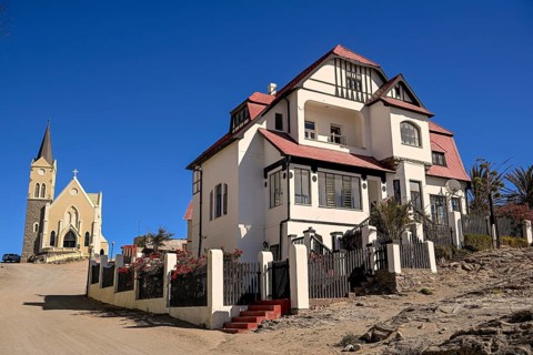 Colonial house facade in the Kirchstraße, in the background the rock church, Lüderitz, Karas