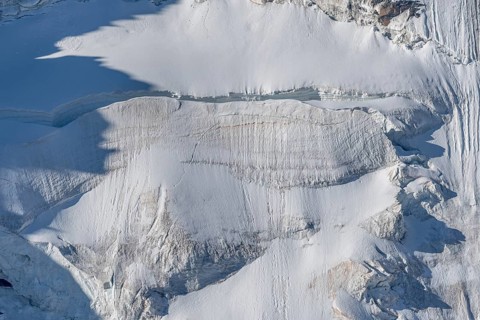 Intricate patterns of ice and rock are showcased in this stunning glacial landscape, revealing the