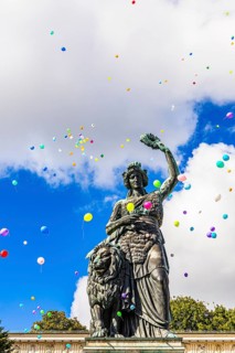 Colourful balloons rise high above the statue of Bavaria into the white-blue sky, grand finale of