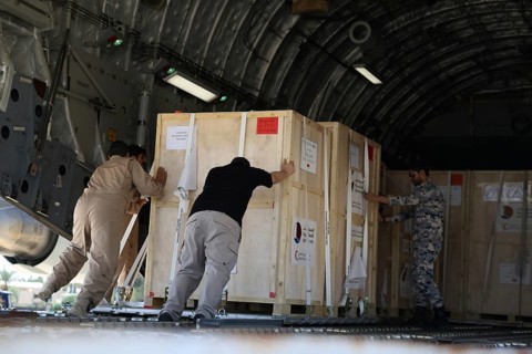 Members of the Qatari Air Force unload humanitarian aid supplies from a transport aircraft at