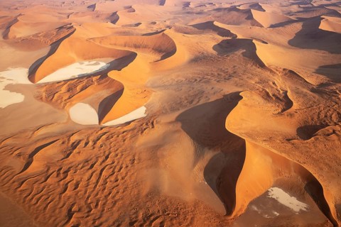 Sand dunes and dry pans in the Namib Desert. In the evening. Aerial view. Namib-Naukluft Park,
