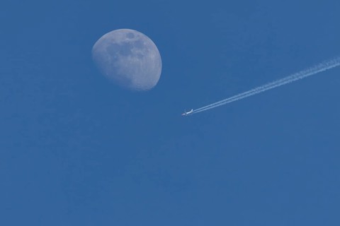 Boeing 737 jet passenger aircraft of Norweign Air with a vapour trial or contrail behind flying in