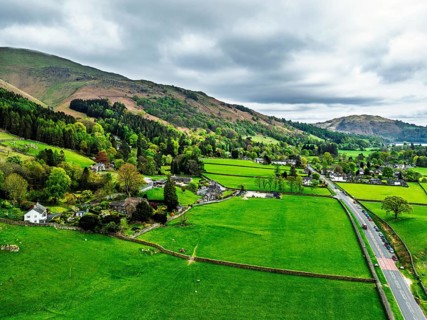 Farms and Mountains over road A591 from a drone, Grasmere Lake, Grasmere, Ambleside, Lake District,
