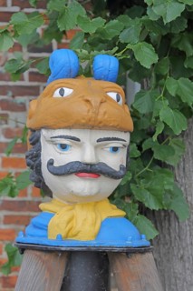 Colourful Swedish head as a landmark, historic wooden head with face and four eyes, tree house, Old