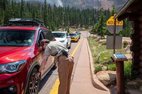 Colorado Springs, Colorado - A Pikes Peak ranger checks the temperature of brakes on a car