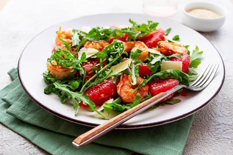 Fresh shrimp salad with arugula, grapefruit, and parmesan served in a bowl