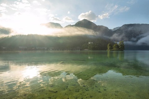 Mystical morning at Königssee in Schönau with boathouses and Christlieger. Sunrise and beautiful