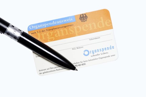 Organ donor card with biros on white background, symbolic image of organ donation