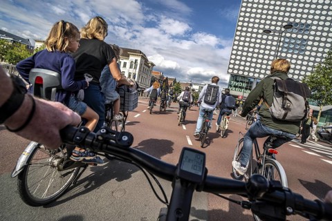 Ride your bike on the central cycle path on Lange Viestraat, Vredenburg, in the city centre of