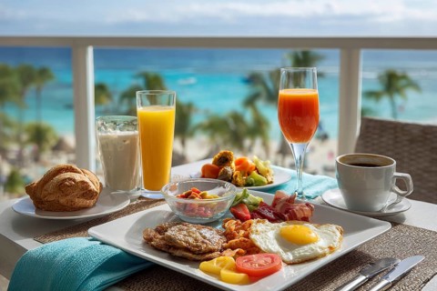 Breakfast in bed on vacation at a luxury hotel room with beautiful ocean view, AI generated