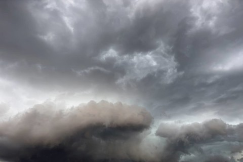 Below dark discoloured storm clouds Cloud roll above grey clouds Rain clouds heralding
