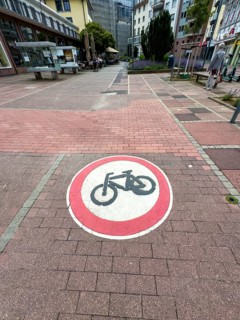Official traffic sign painted on cobblestones in pedestrian zone Use of passage forbidden for