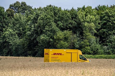 DHL parcel van, electric vehicle, on the way to a customer, rural, driving along a dirt track