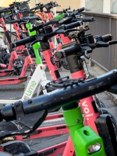 Many rental e-scooters parked on a pavement in Wuppertal, Germany