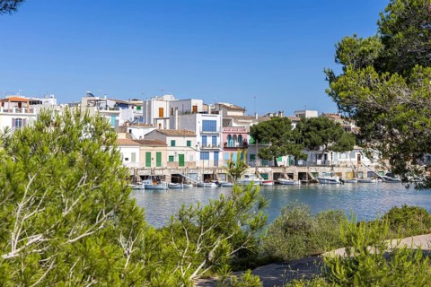 Portocolom fishing village on Majorca with boats and colourful houses Holiday by the sea in