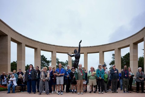 Funeral service, mourning relatives pause during the playing of the US national anthem, bronze